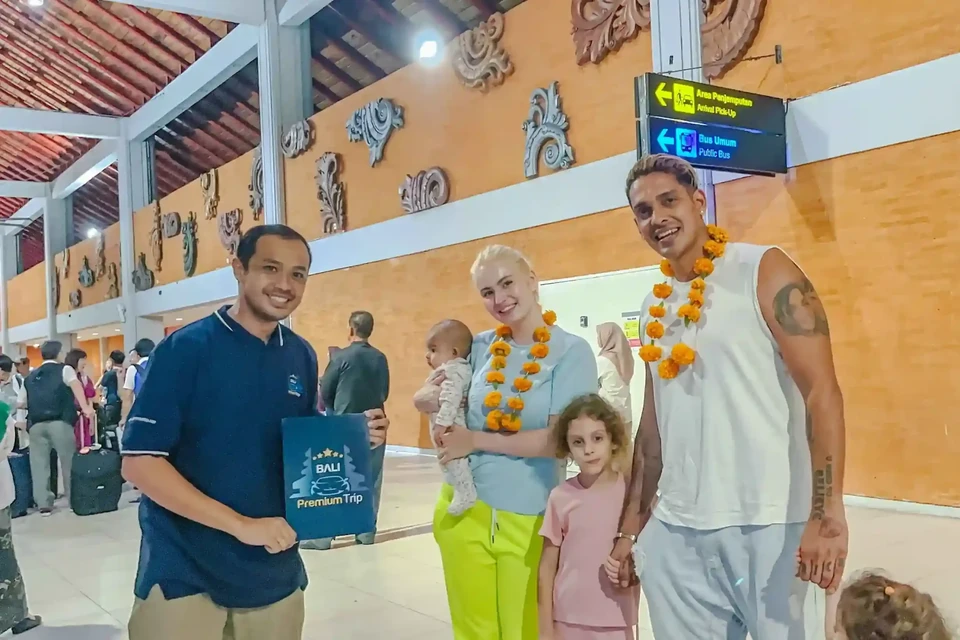 Bali Premium Trip staff welcoming a family at Ngurah Rai Airport arrivals