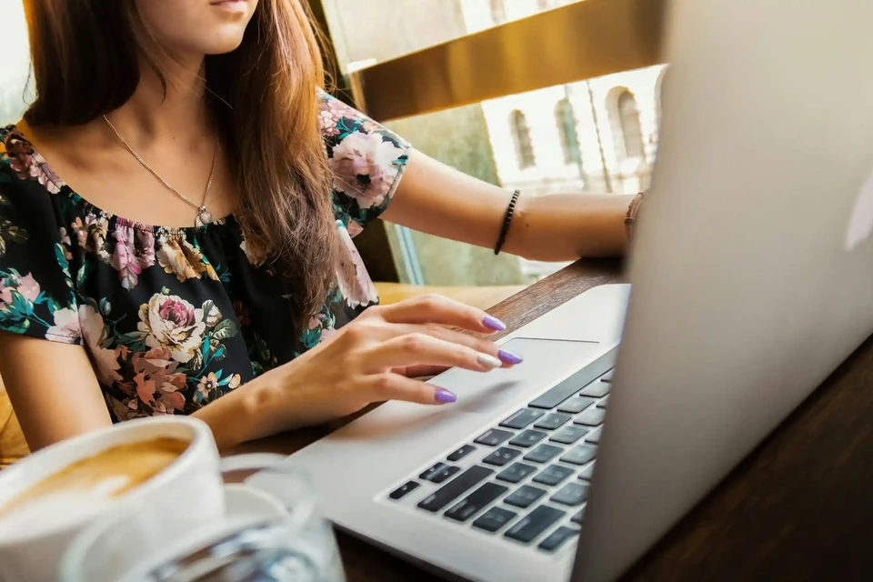 Remote worker typing on a laptop next to a coffee