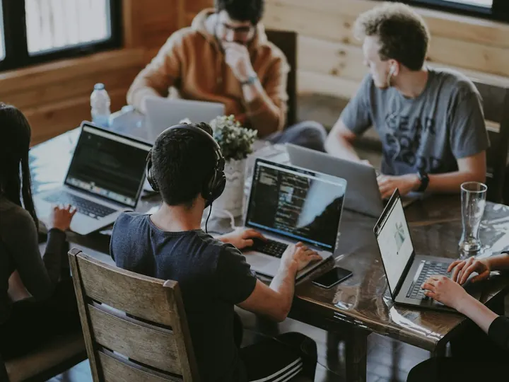 Remote workers on laptops at a shared table