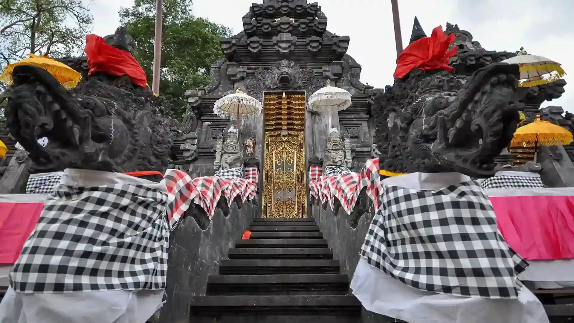 Goa Lawah temple gate wrapped in black-and-white checked cloth